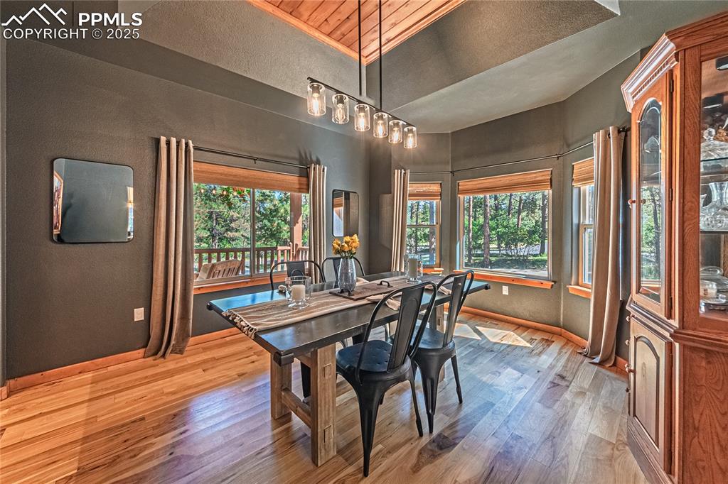 Image 12 of 50: Dining area with wood finished floors and a textured wall