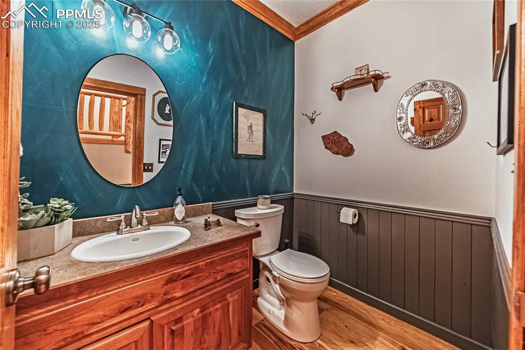Image 13 of 50: Bathroom featuring light wood finished floors, ornamental molding, vanity,