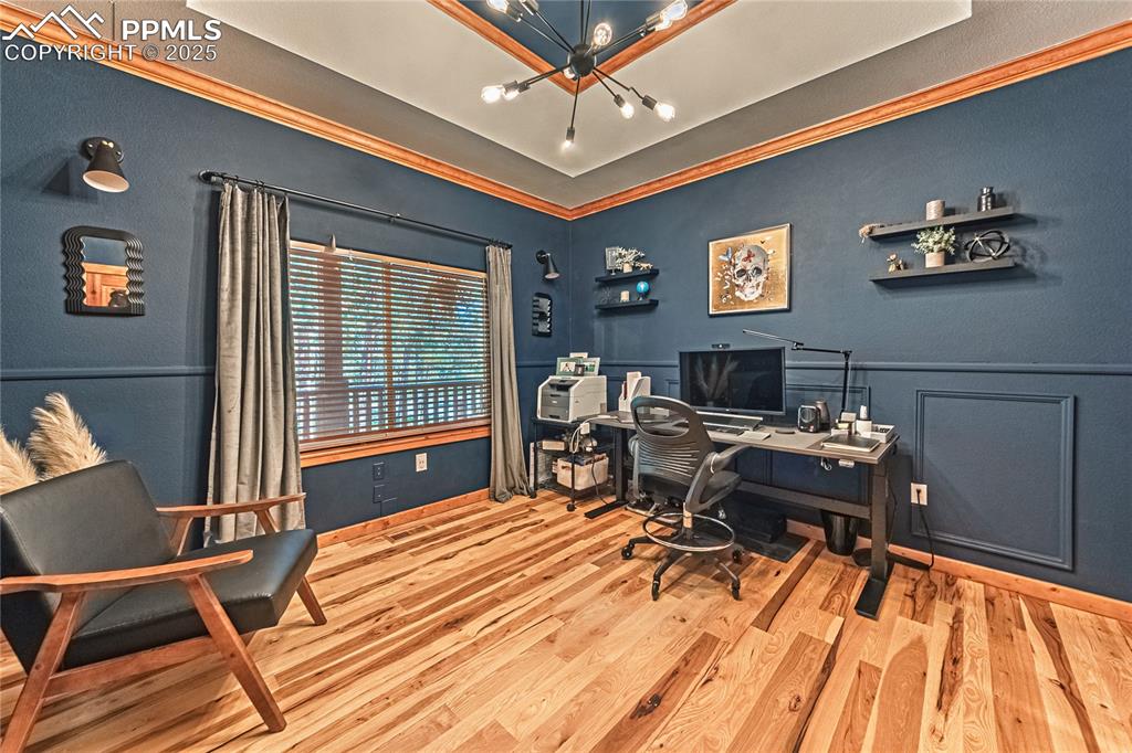 Image 20 of 50: Office area with crown molding, a chandelier, light wood-style floors, and