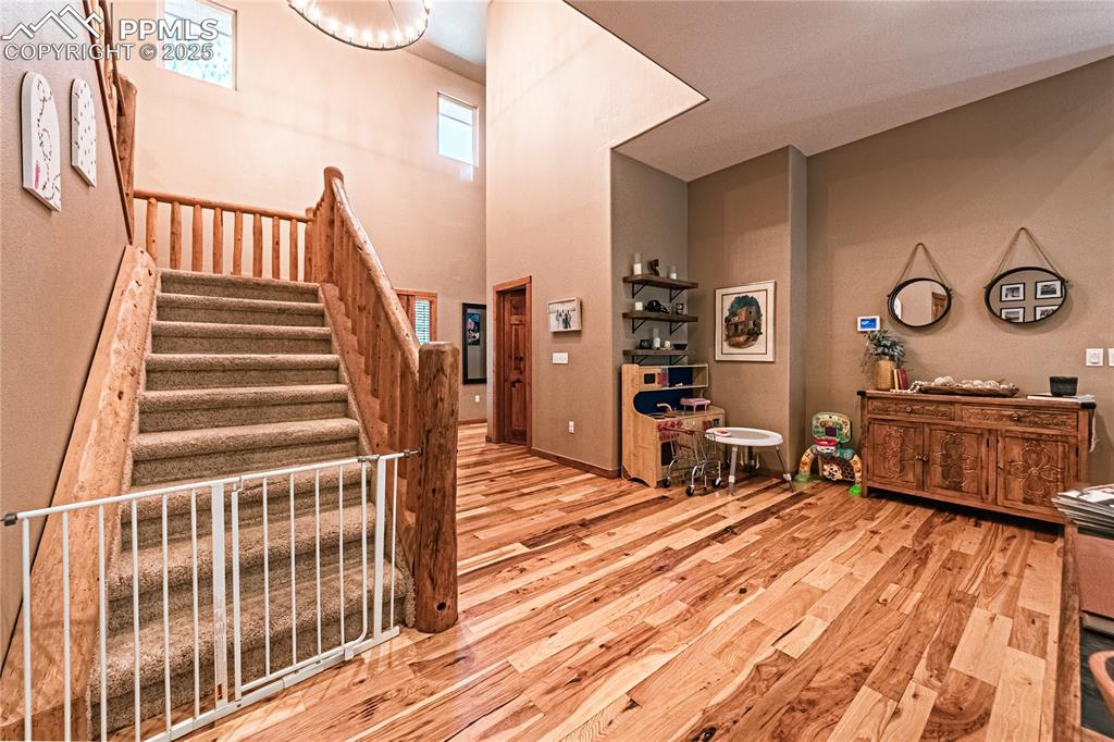 Image 22 of 50: Stairway featuring wood finished floors and a towering ceiling