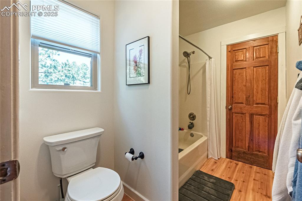 Image 25 of 50: Full bath with shower / tub combo and light wood-style flooring