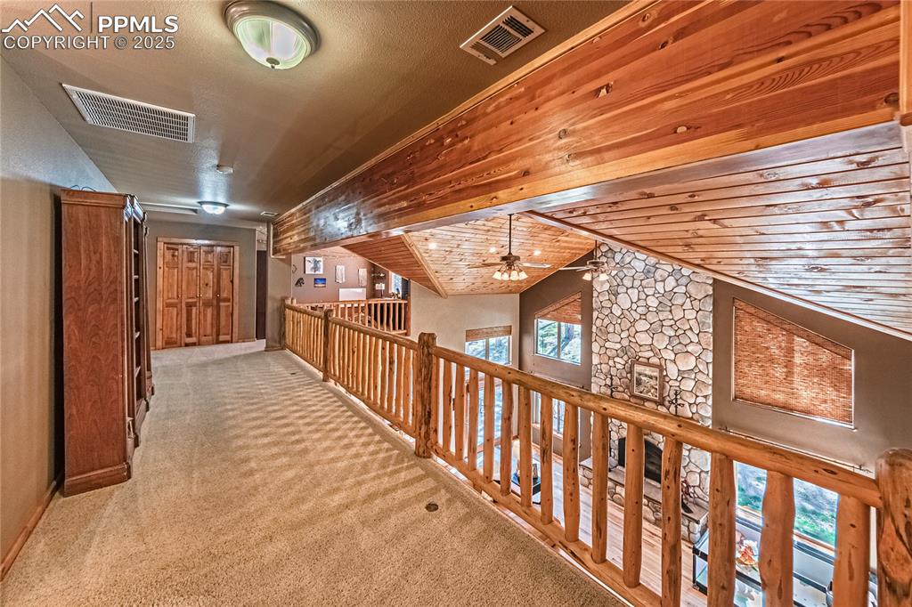 Image 26 of 50: Hallway featuring vaulted ceiling, light carpet, and wooden ceiling