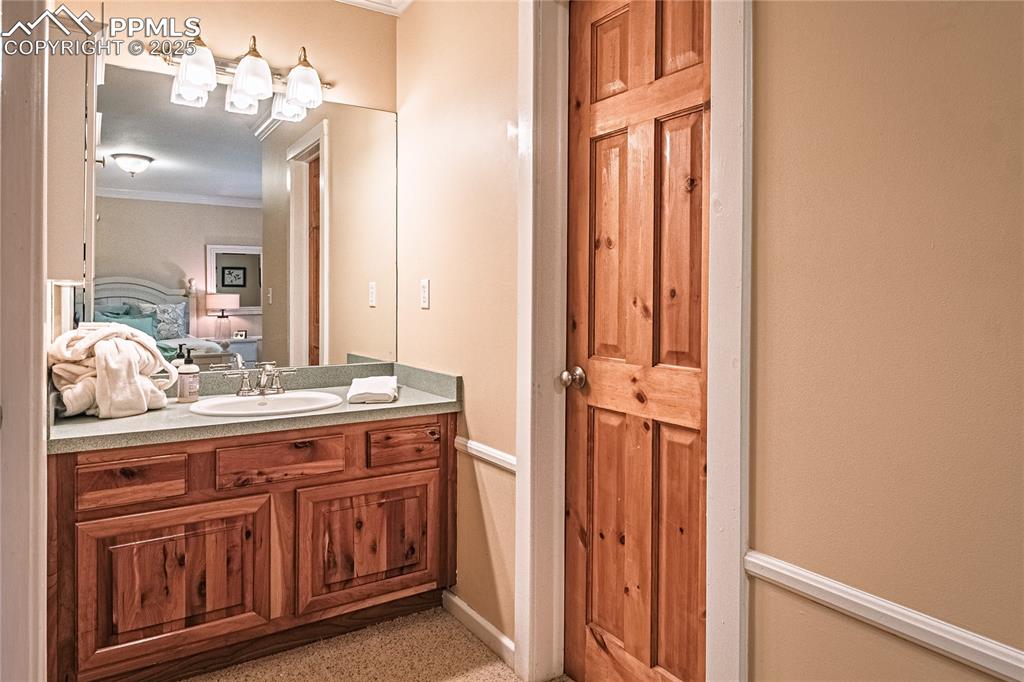 Image 29 of 50: Ensuite bathroom with vanity and crown molding