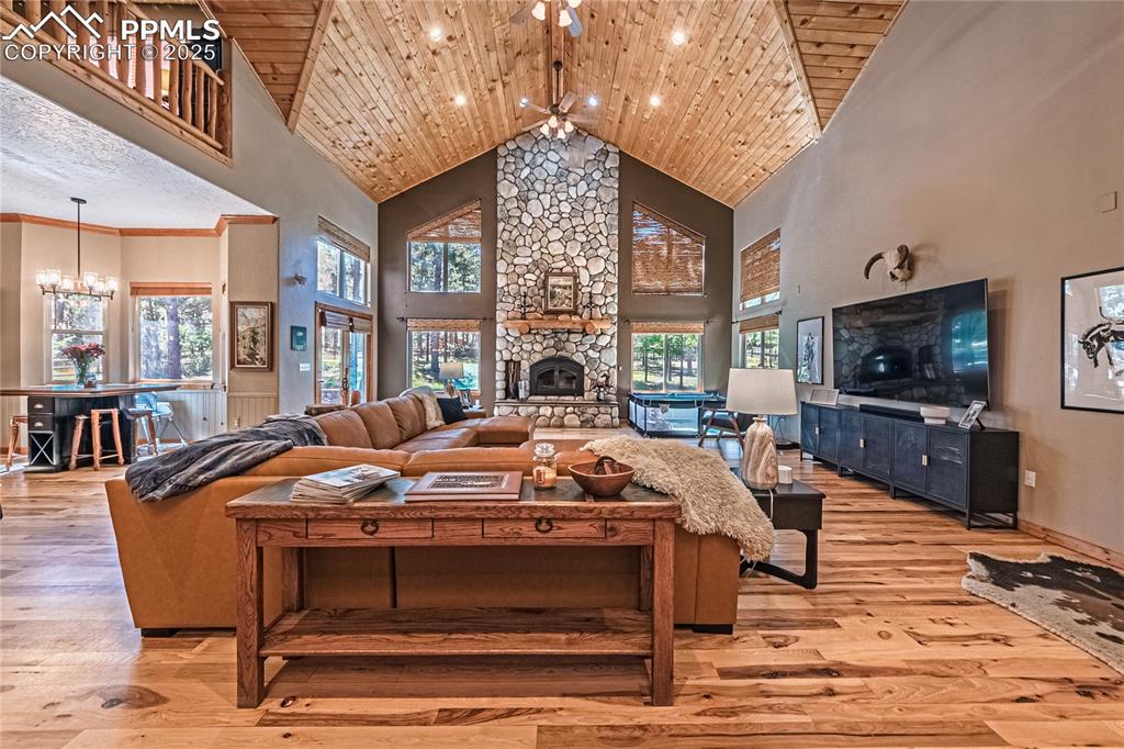 Image 3 of 50: Living area featuring a chandelier, high vaulted ceiling, wood ceiling, lig