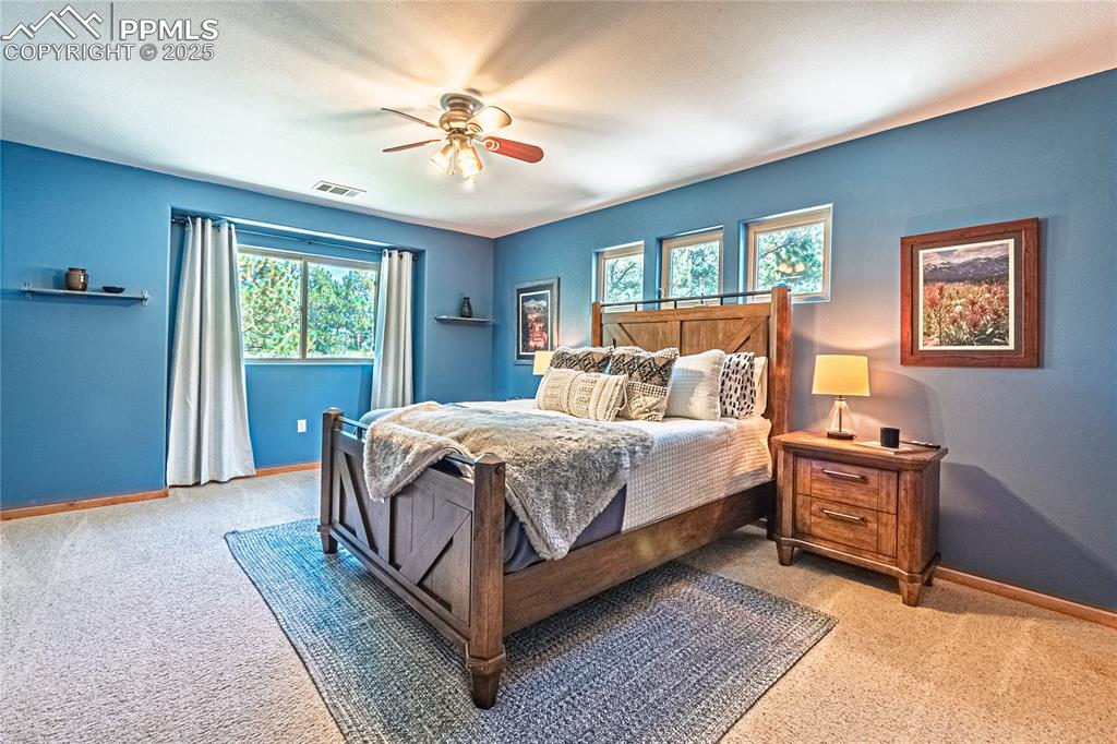 Image 33 of 50: Carpeted bedroom with baseboards and a ceiling fan