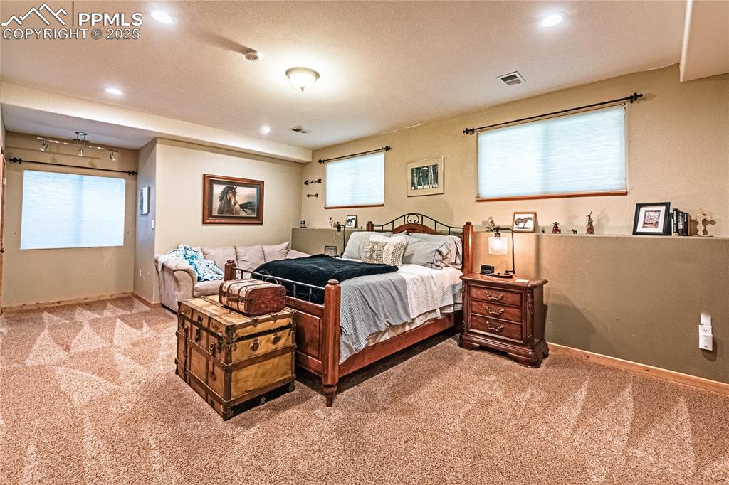Image 41 of 50: Bedroom featuring multiple windows, light colored carpet, recessed lighting