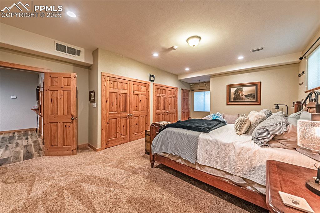 Image 42 of 50: Bedroom with carpet floors, recessed lighting, a closet, and multiple windo