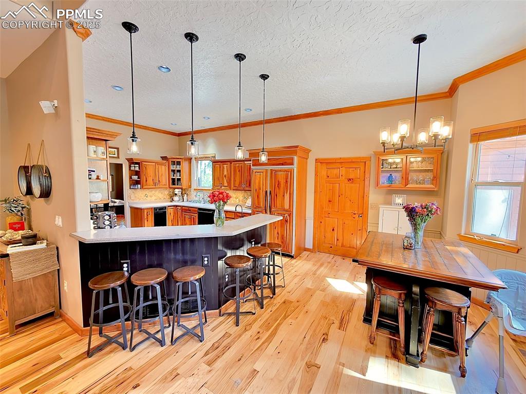 Image 7 of 50: Kitchen with glass insert cabinets, a kitchen breakfast bar, a peninsula, b