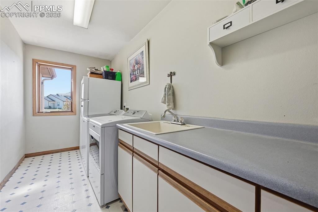 Image 30 of 50: Large laundry with sink and folding counter.