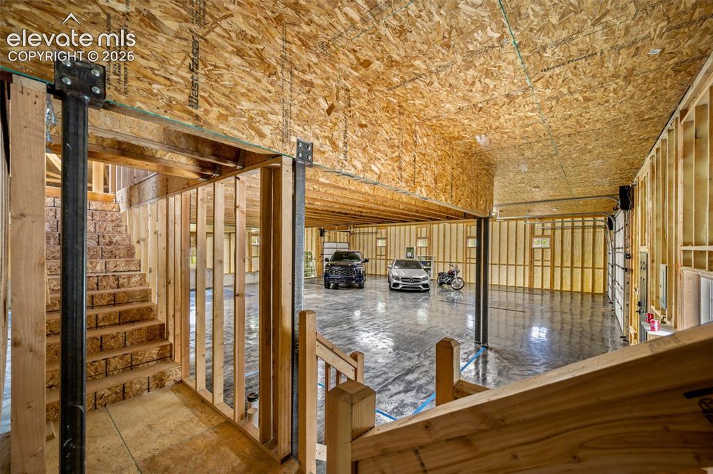 Image 38 of 46: Entry to garage and staircase to unfinished 552 sq ft potential.