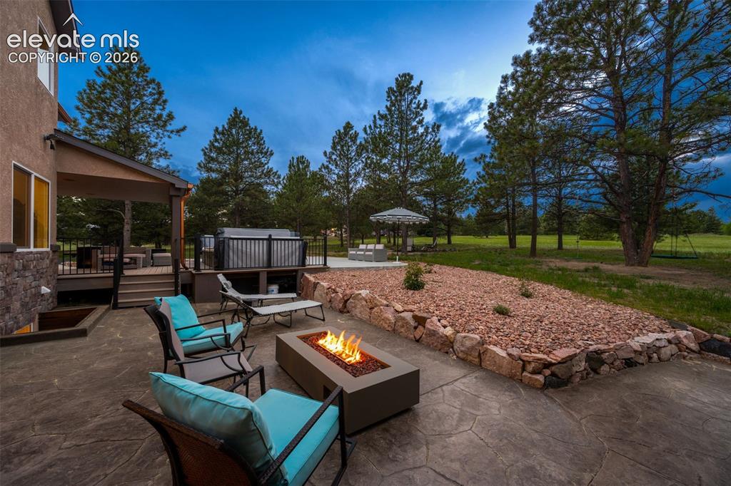 Image 44 of 46: Stamped concrete patio and natural gas fire feature