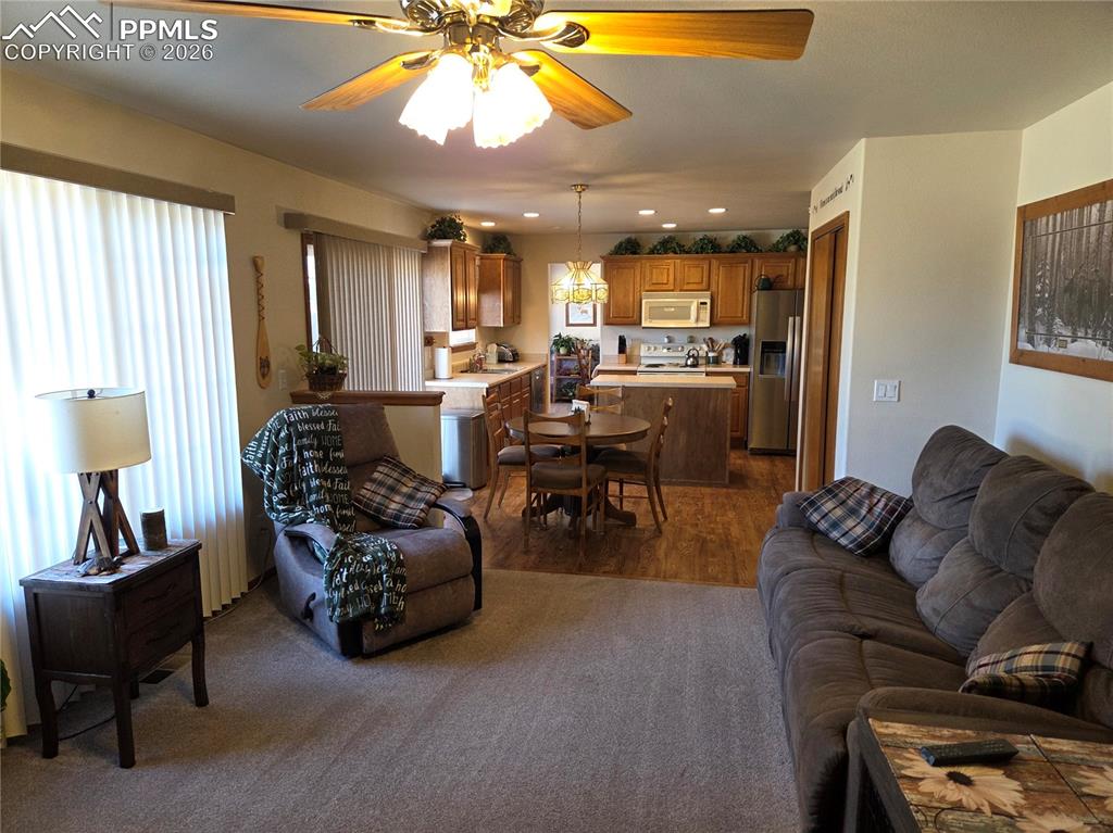 Image 11 of 38: Living area with a ceiling fan, recessed lighting, and dark wood-style floo