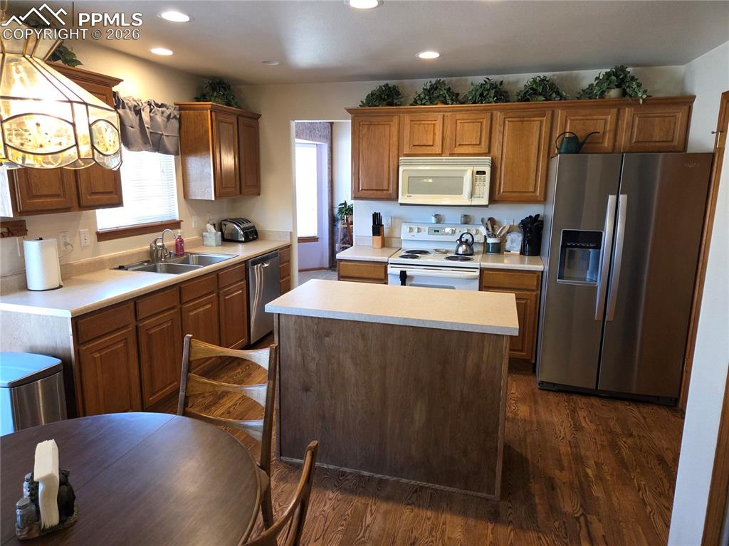 Image 14 of 38: Kitchen with stainless steel appliances, light countertops, a center island