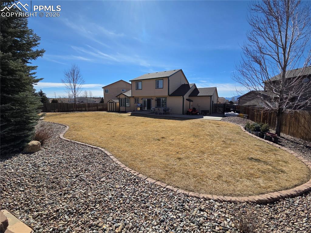 Image 19 of 38: Back of house with a fenced backyard and stucco siding