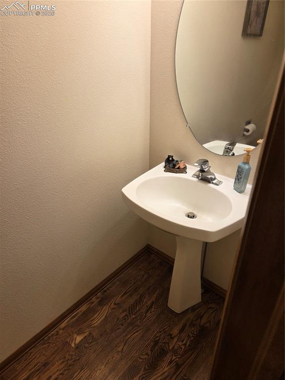Image 26 of 38: Bathroom with dark wood finished floors and baseboards
