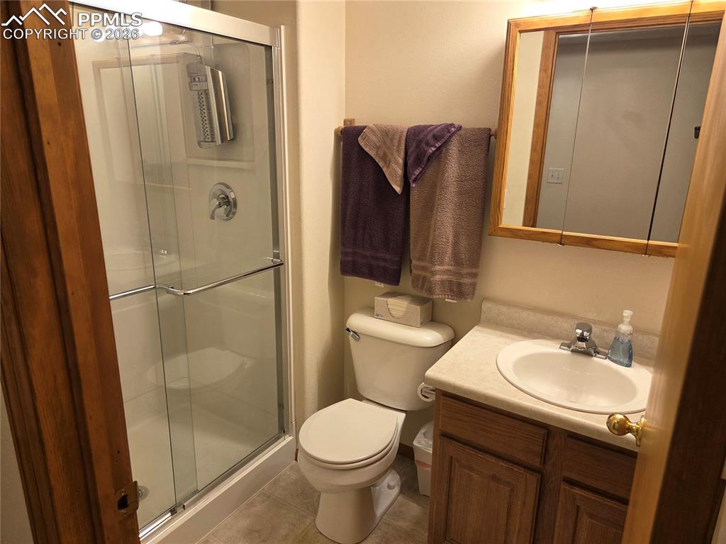 Image 29 of 38: Bathroom with vanity, a stall shower, and light tile patterned flooring