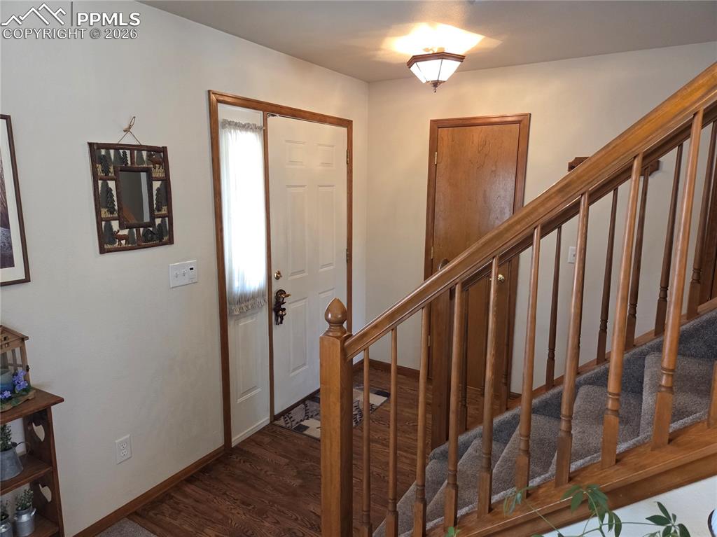 Image 3 of 38: Foyer featuring stairs and dark wood finished floors