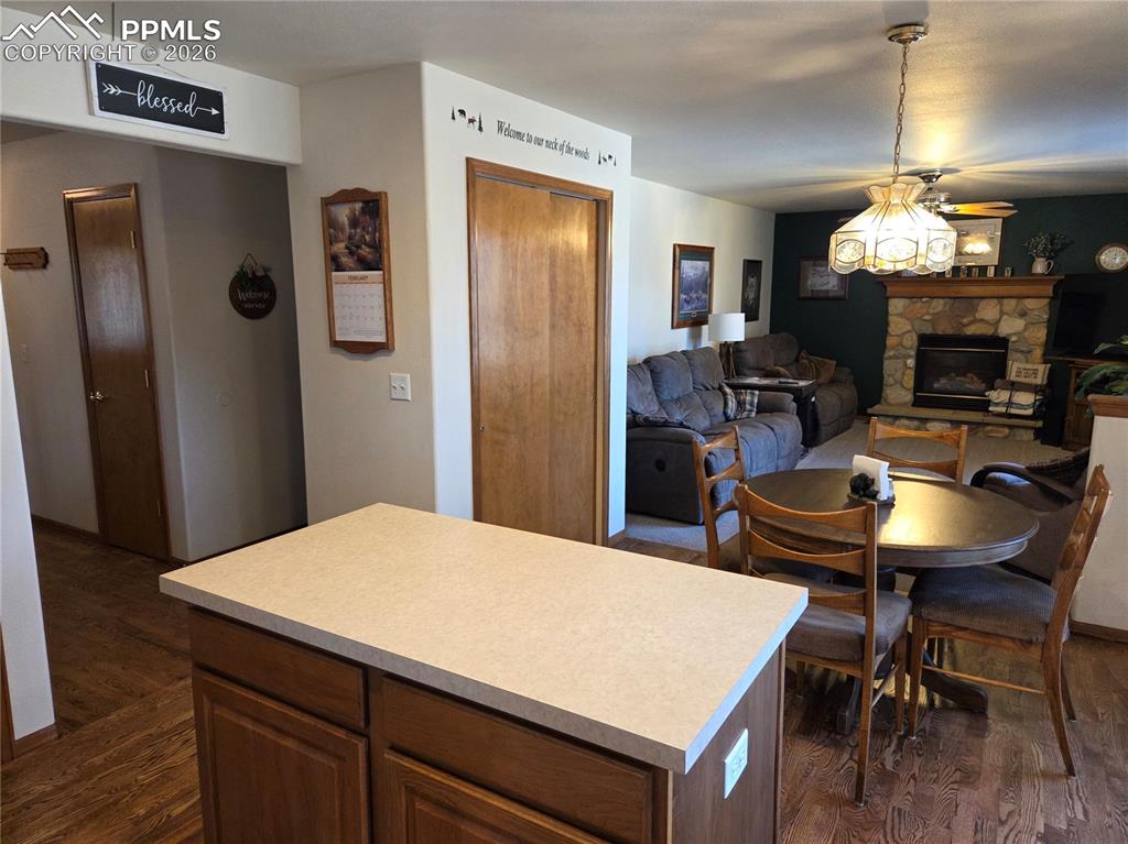 Image 9 of 38: Kitchen featuring light countertops, a kitchen island, and dark wood-type f