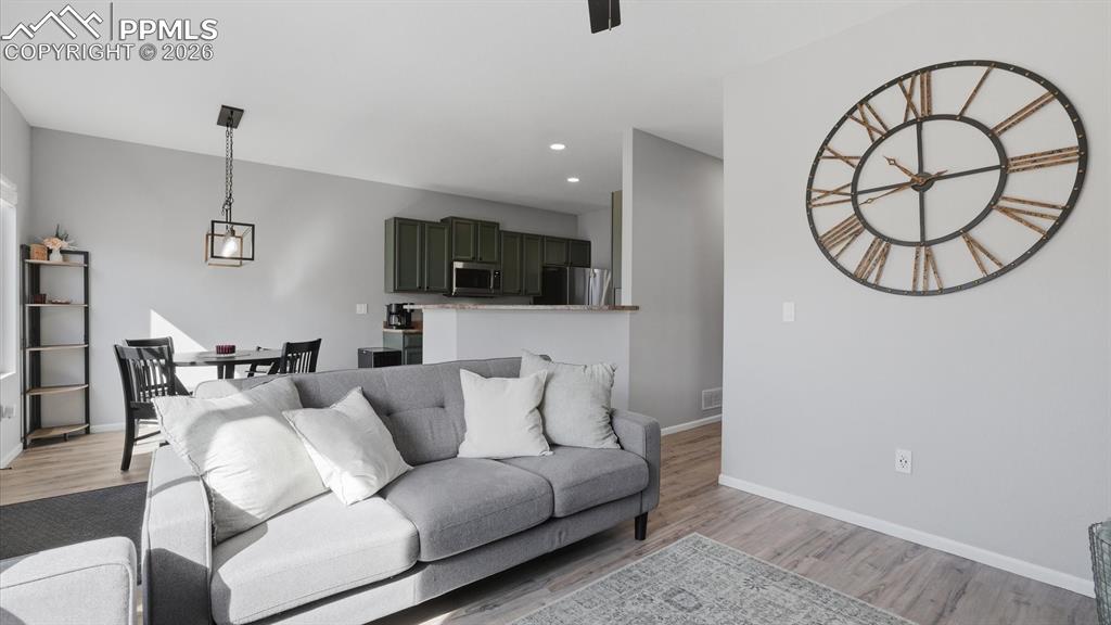 Image 11 of 50: The Family Room boasts LVP flooring, a lighted ceiling fan, and fireplace w