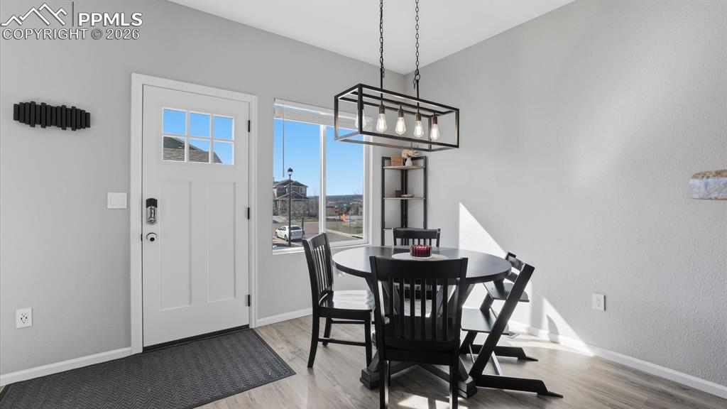 Image 12 of 50: The Dining Area offers a contemporary light fixture and walk out to the sta