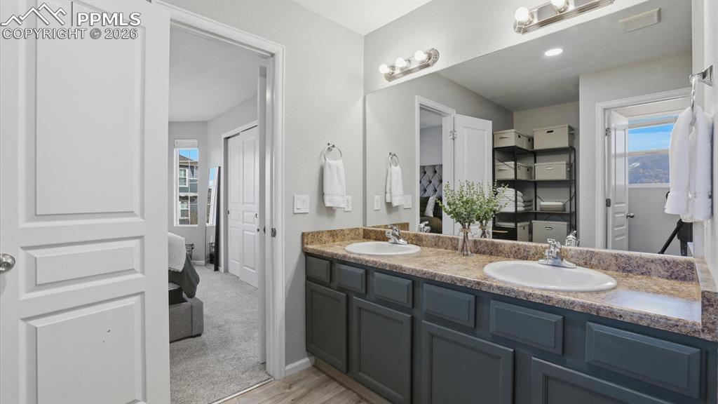 Image 28 of 50: Ensuite Primary Bathroom with dual sink vanities, mirror, and enclosed tile