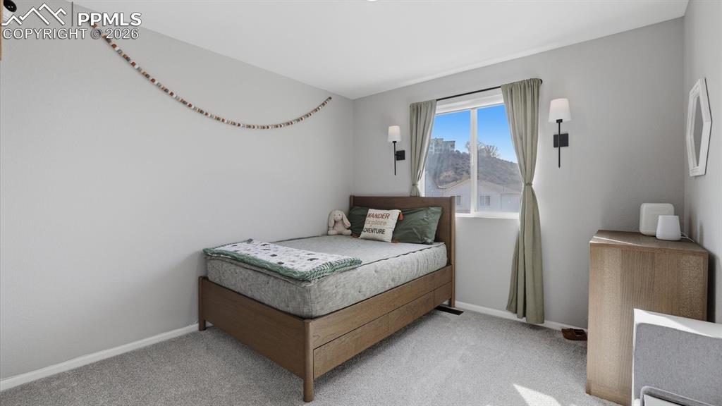 Image 29 of 50: Upper Level Bedroom #2 with neutral carpet.