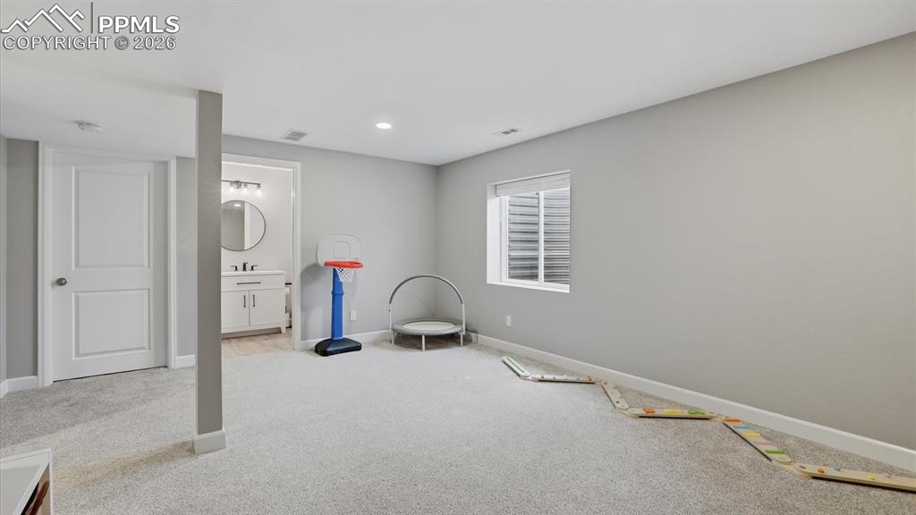 Image 35 of 50: Basement Family/Rec Room with neutral carpet and Full Bathroom.