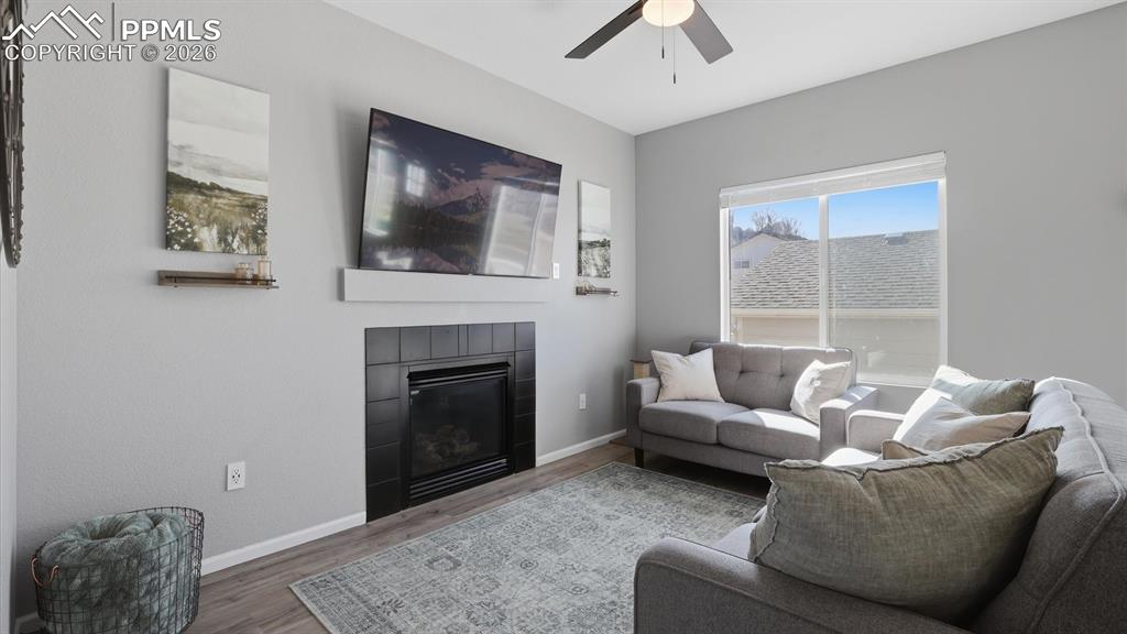 Image 9 of 50: The Family Room boasts LVP flooring, a lighted ceiling fan, and fireplace w