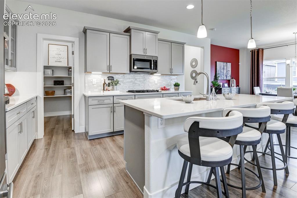 Image 12 of 31: Kitchen featuring a large island with countertop seating, stainless steel a