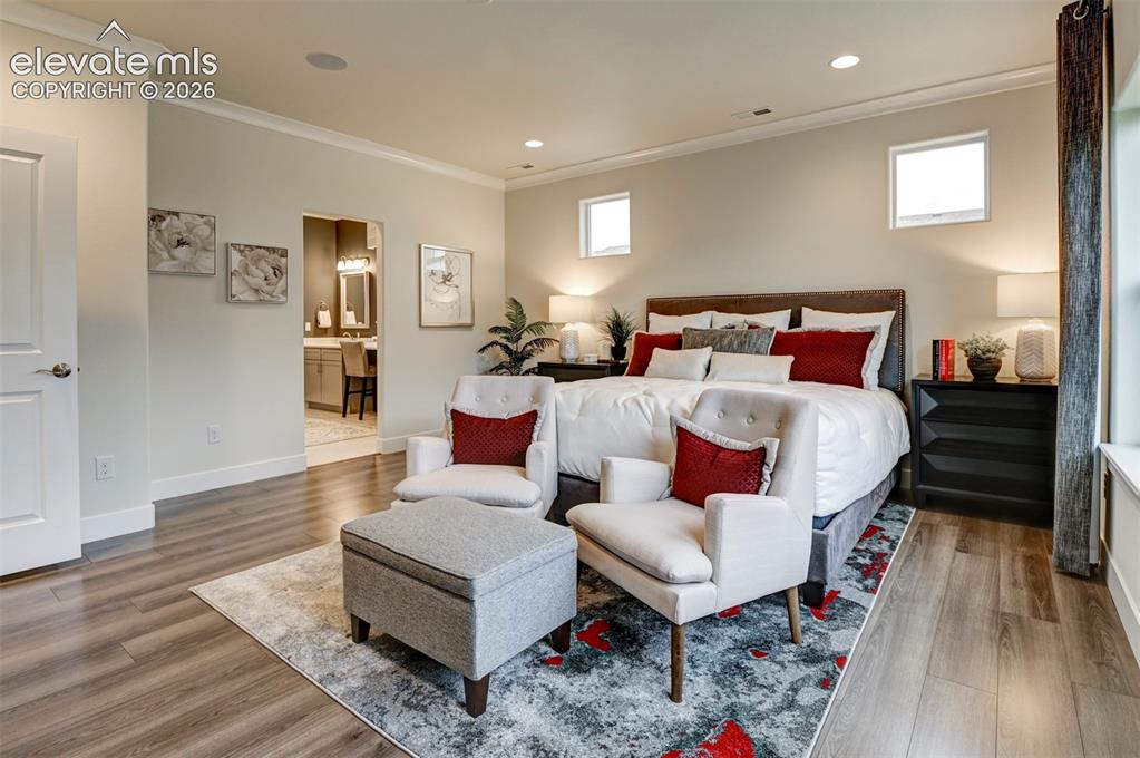 Image 14 of 31: Wood-finish flooring, recessed lighting, crown molding, and two transom win