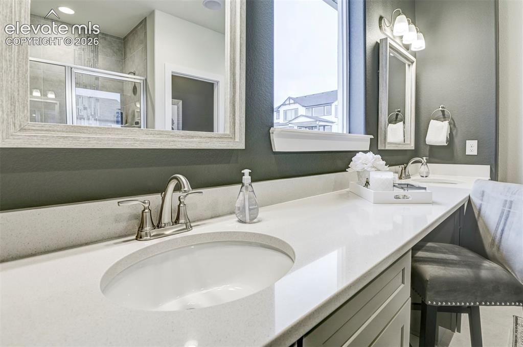 Image 20 of 31: Dual vanity with integrated sinks, brushed nickel fixtures, a framed mirror