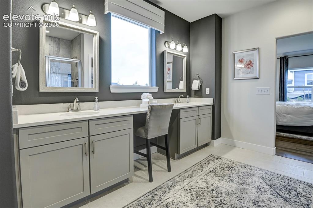 Image 22 of 31: Dual vanities with undermount sinks and light gray cabinetry