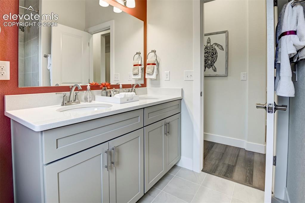 Image 27 of 31: Double vanity with white countertop, chrome fixtures, and shaker-style cabi