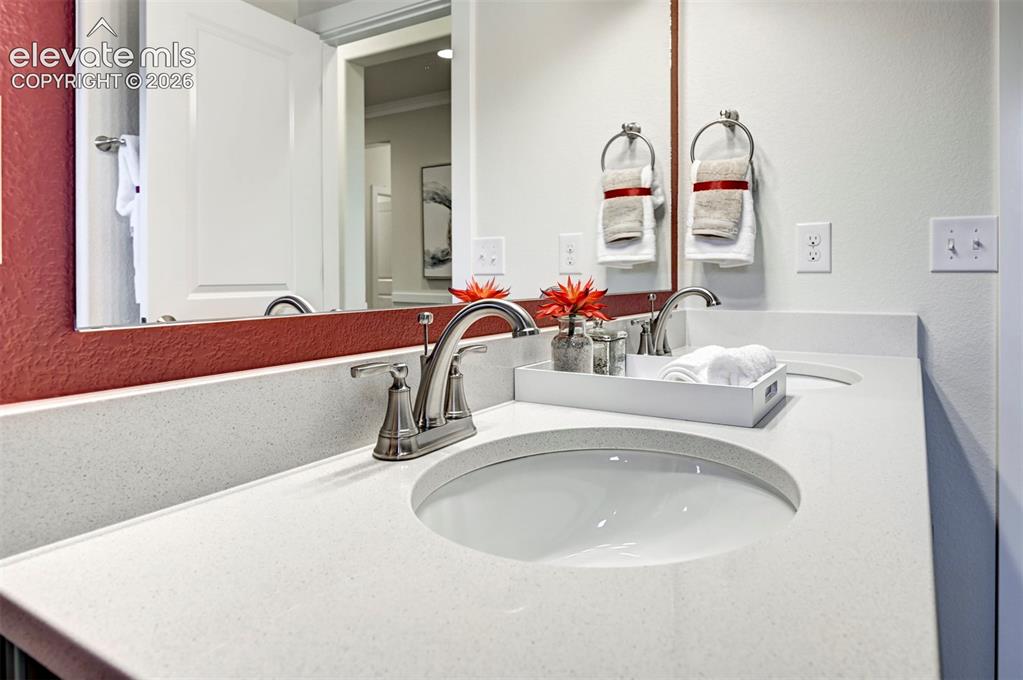 Image 28 of 31: Double vanity with integrated sinks, brushed nickel fixtures, and light-ton
