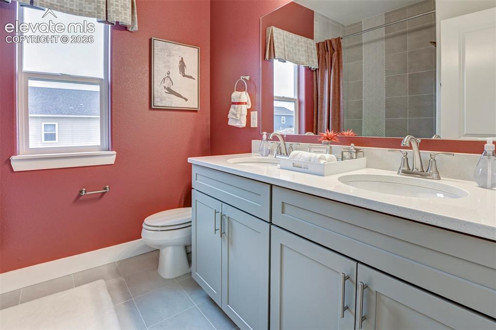 Image 29 of 31: Dual vanity with light gray cabinetry, white countertops, and undermount si