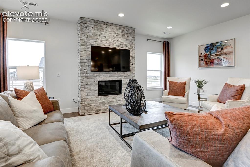 Image 8 of 31: Stone-finish fireplace surround with integrated fireplace, recessed lightin