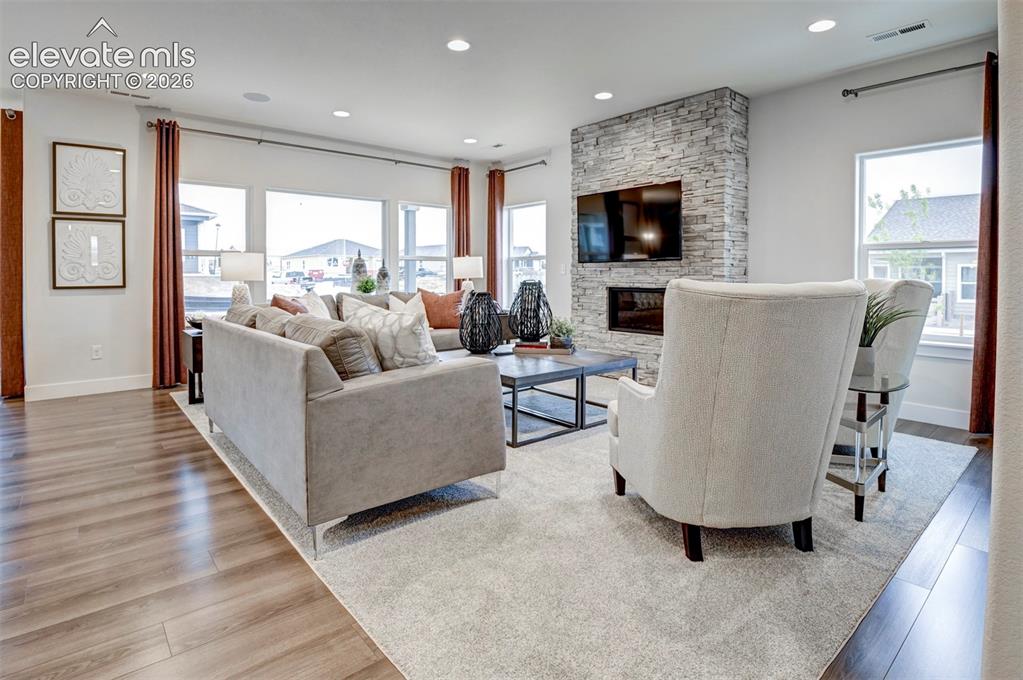 Image 9 of 31: Wood-finish flooring, recessed lighting, expansive windows, a stacked stone