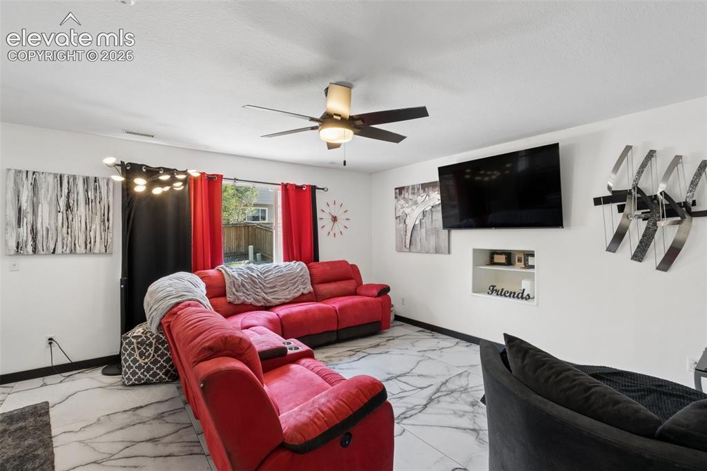 Image 10 of 31: Living area featuring a ceiling fan, recessed niche, and tile flooring