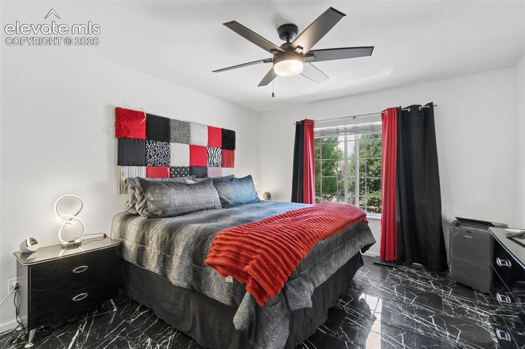 Image 11 of 31: Black marble-look tile flooring, white walls, and a window with a metal gri