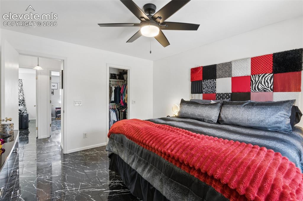 Image 12 of 31: Black marble-effect flooring, ceiling fan with integrated lighting, and whi