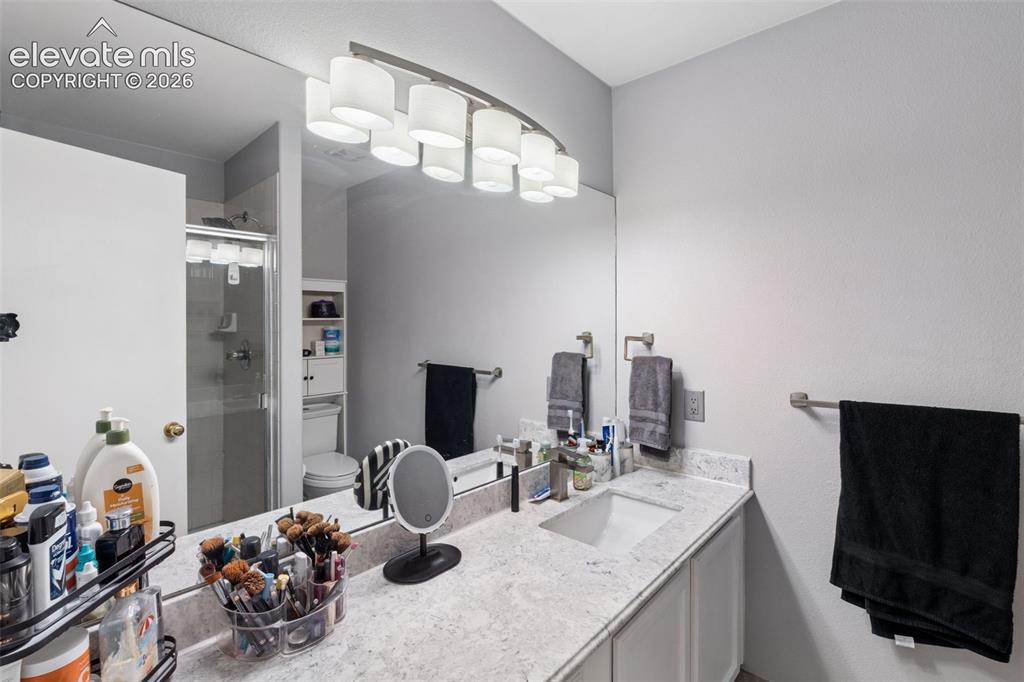 Image 13 of 31: Vanity with an integrated rectangular sink, granite-style countertop, and a