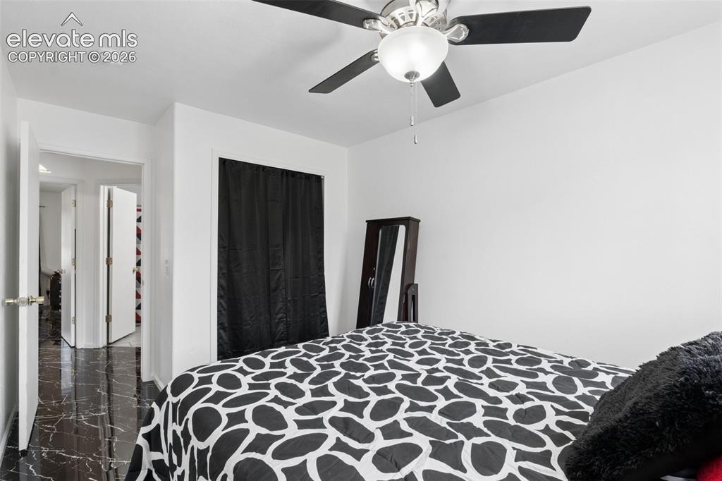Image 15 of 31: Black marble-finish flooring, white walls, and a ceiling fan with integrate