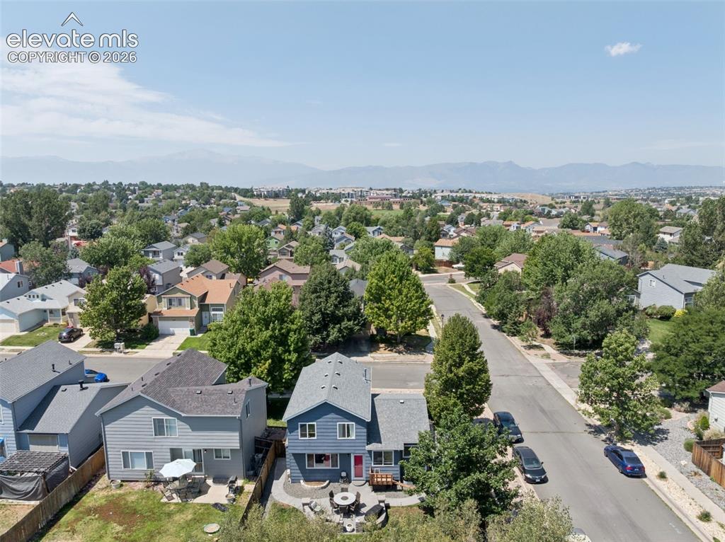 Image 26 of 31: Expansive neighborhood setting with mature trees and mountain scenery