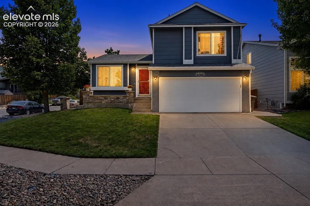 Image 31 of 31: Two-story residence with a two-car garage, concrete driveway, and a stone f