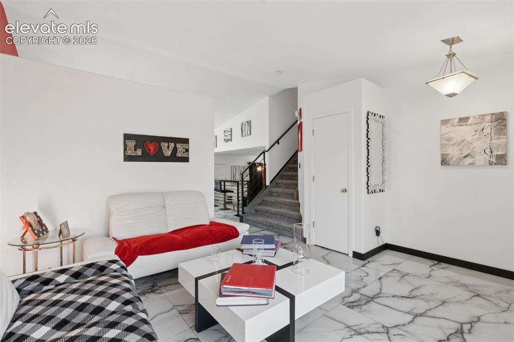 Image 6 of 31: White walls, black trim, and marble-finish flooring