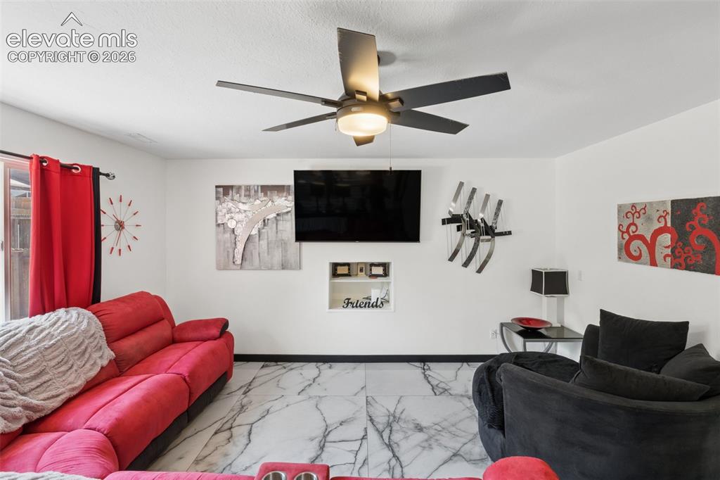 Image 9 of 31: White walls with dark trim, marbling tile flooring, built-in shelving, blac