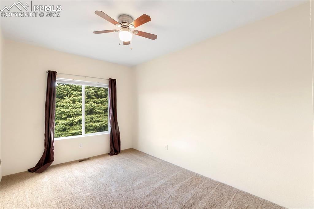 Image 14 of 31: Carpeted spare room with ceiling fan
