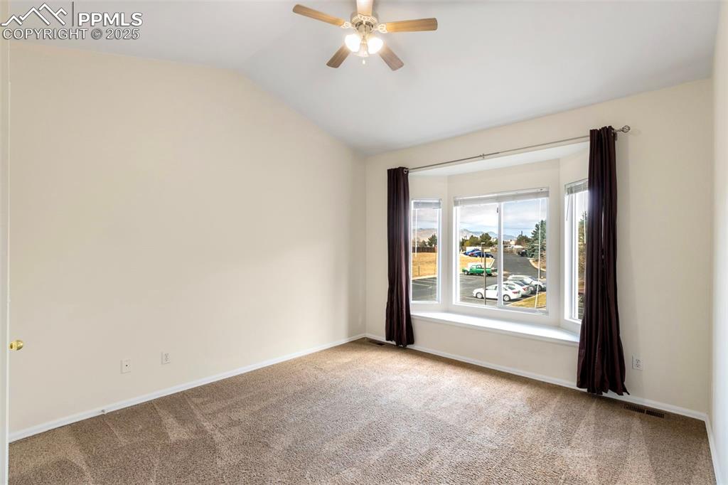 Image 18 of 31: Carpeted empty room with lofted ceiling and ceiling fan