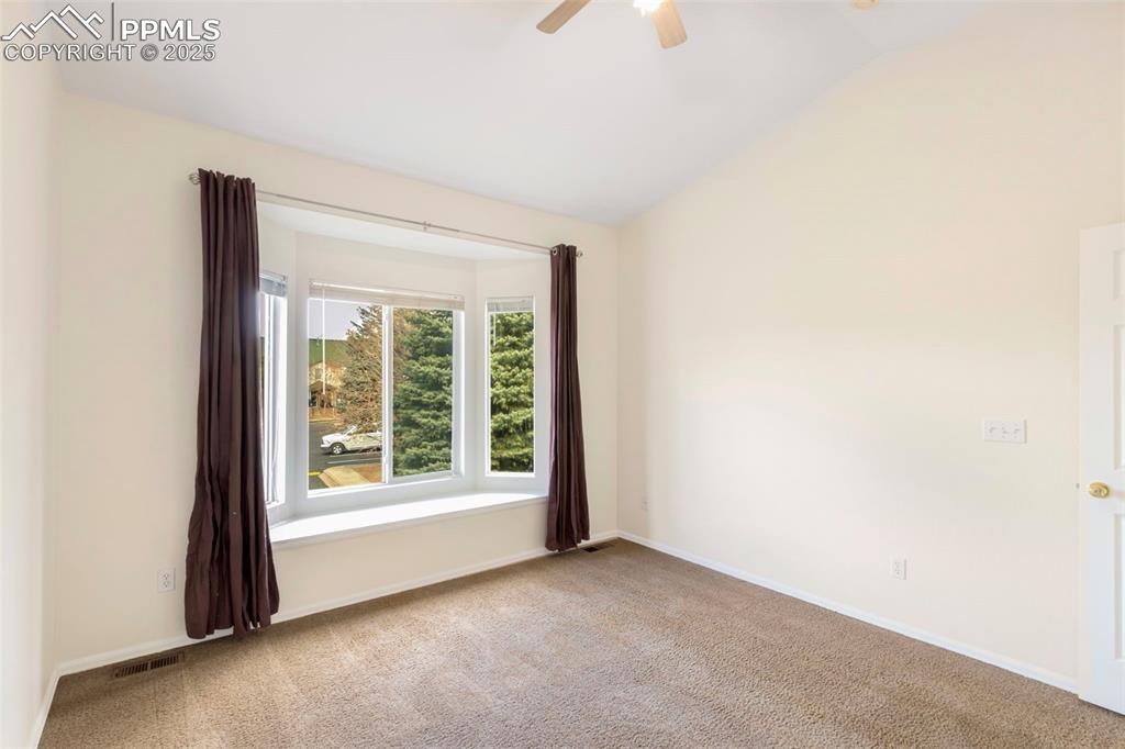 Image 19 of 31: Spare room with light colored carpet, lofted ceiling, and a ceiling fan