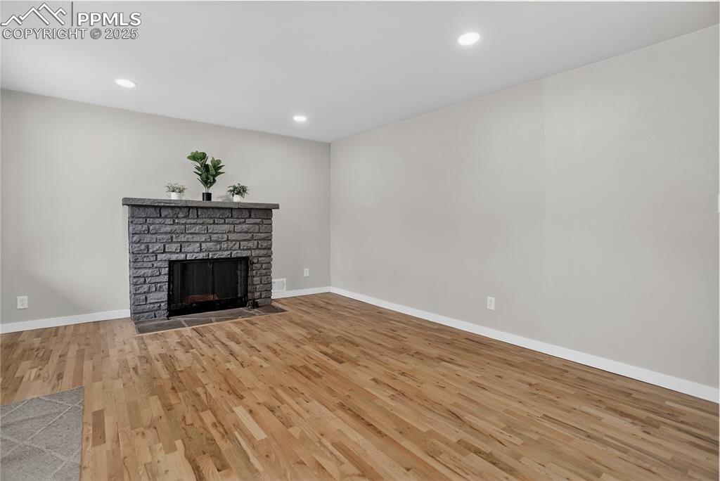 Image 4 of 21: Living room w/ woodburning fireplace